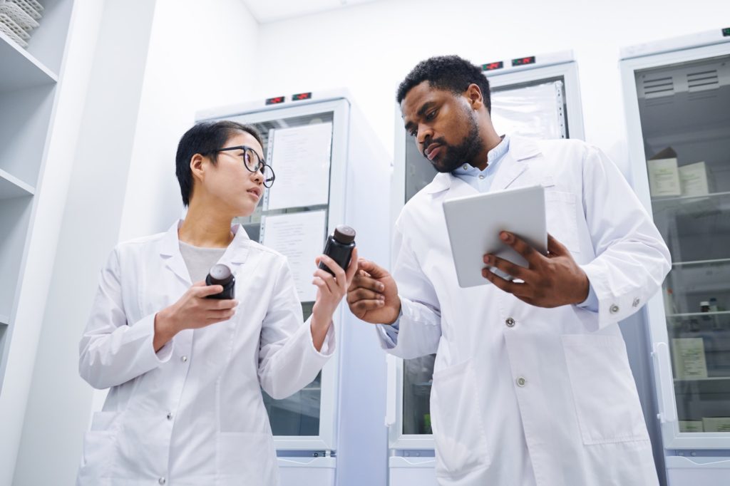 Pharmacists keeping records in medical storage room